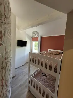 a bedroom with two bunk beds and a tv at Les Prairies de l'Encrême in Céreste