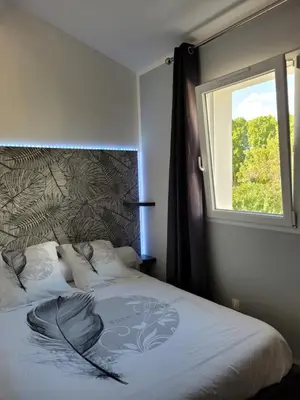a bedroom with a large bed with a window at Les Prairies de l'Encrême in Céreste