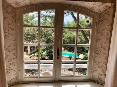 a window with a view of a pool seen through it at Chambres dans le Luberon - Bois Romay in La Bastide-des-Jourdans