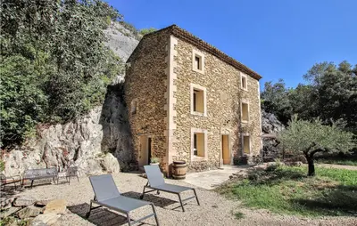 a stone building with two chairs and a tree at 2 Bedroom Amazing Home In Apt in Apt