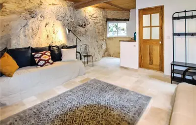 a living room with a couch and a stone wall at 2 Bedroom Amazing Home In Apt in Apt