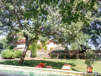 a park with two chairs and a bench under a tree at Villa élégante avec piscine privée à Ansouis, vues montagne in Ansouis
