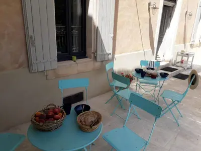 a table with chairs and a table with fruit on it at MAISON BOURGUES in Lioux