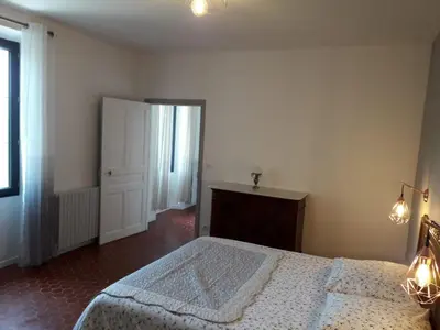 a bedroom with a large bed and a window at MAISON BOURGUES in Lioux