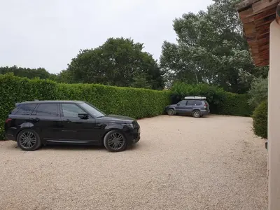 two cars parked in the driveway of a house at Petit nid douillet en Luberon avec spa in Ansouis