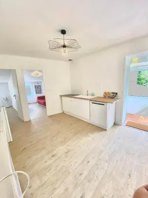 a white kitchen with a sink and a counter at Il y a le Soleil, la Campagne et la Mer in Martigues