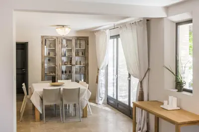 a dining room with a white table and chairs at high standard provencal bastide with heated pool in lourmarin in the luberon, vaucluse. 10 people in Lourmarin