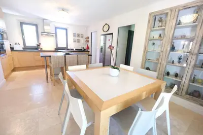 a dining room with a wooden table and white chairs at high standard provencal bastide with heated pool in lourmarin in the luberon, vaucluse. 10 people in Lourmarin