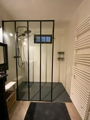 a shower with a glass door in a room at Au petit bonheur in LʼIsle-sur-la-Sorgue