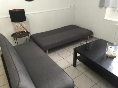 a small room with a couch and a table at Logement sur pte cour, rez de chaussée, WIFI, CLIM in Vedène