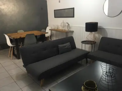 a living room with a couch and a table at Logement sur pte cour, rez de chaussée, WIFI, CLIM in Vedène
