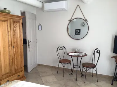 a table and chairs in a room with a mirror at jardin d'antan in Ansouis