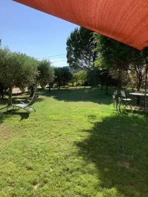 a park with two benches and a table and trees at jardin d'antan in Ansouis