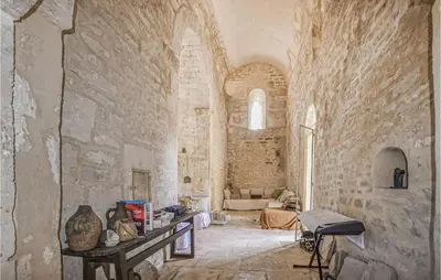 a room with a stone wall with a table in it at Awesome Home In Bonnieux With Sauna in Bonnieux