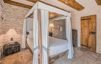 a bedroom with a canopy bed in a room at Awesome Home In Bonnieux With Sauna in Bonnieux