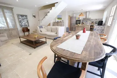 a living room with a wooden table and chairs at charming house with private pool in the heart of the village of aureille in the alpilles, 6 people. in Aureille