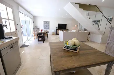 a kitchen and living room with a table with a bowl of fruit at charming house with private pool in the heart of the village of aureille in the alpilles, 6 people. in Aureille