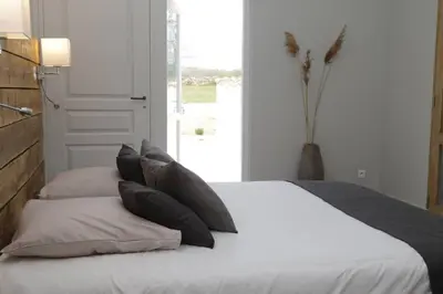 a bedroom with a bed with pillows and a window at Villa pleine campagne, piscine chauffée , Lubéron in Lacoste