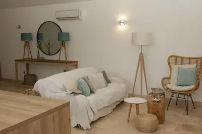 a living room with a couch and a mirror at Villa pleine campagne, piscine chauffée , Lubéron in Lacoste