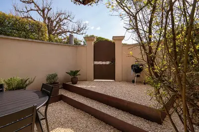 a backyard with a fence and a set of stairs at Le Mas des Sablières in Oppède