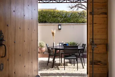 a table and chairs in a patio with a table and chairs at Le Mas des Sablières in Oppède