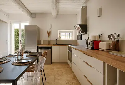 a kitchen with a table and a counter top at Le Mas des Sablières in Oppède
