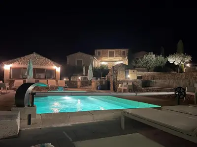 a swimming pool at night with a house at Villa Abayers in Apt