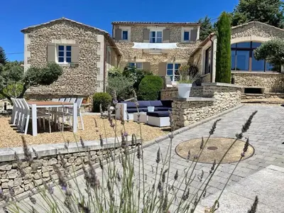a stone house with a patio and a table and chairs at Grands Abayers in Apt