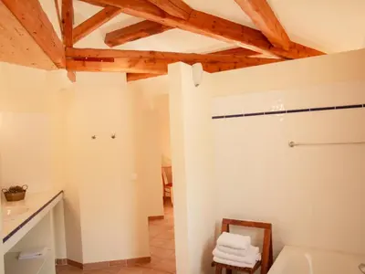 a bathroom with white walls and wooden ceilings at Villa Bellegarde in Saignon