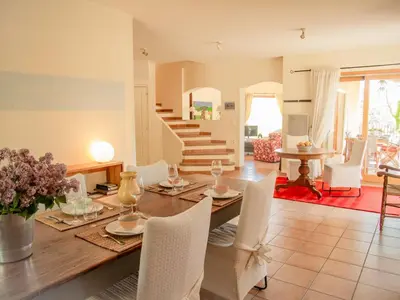 a dining room with a table and white chairs at Villa Bellegarde in Saignon