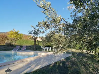 a pool with two chairs and a table in a yard at Maison au calme entre vignes et Luberon in La Motte-dʼAigues