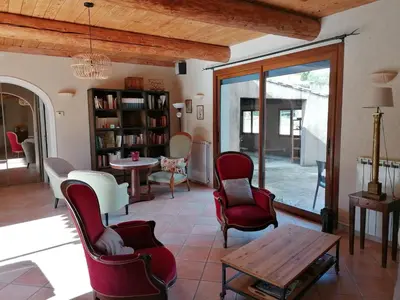 a living room with red chairs and a table at Maison au calme entre vignes et Luberon in La Motte-dʼAigues