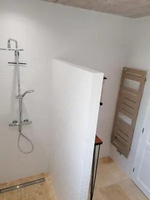 a bathroom with a shower and a white wall at Maison au calme entre vignes et Luberon in La Motte-dʼAigues