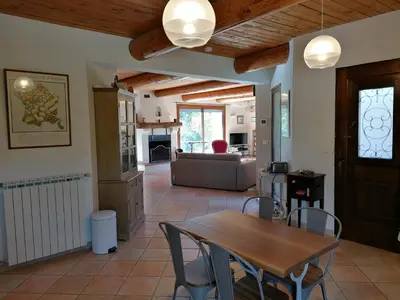a living room with a wooden table and chairs at Maison au calme entre vignes et Luberon in La Motte-dʼAigues