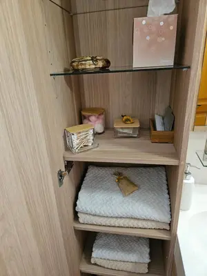 a shelf with towels and other items in a room at Au pied du Massif des Costes in Pélissanne