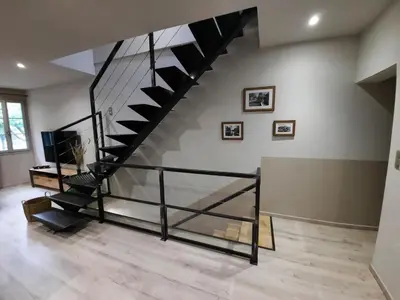 a black staircase in a room with a floor at Le Loft sur les quais in LʼIsle-sur-la-Sorgue