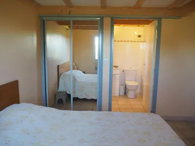 a bedroom with a bed and a bathroom with a toilet at Cottage in Luberon near Apt Market in Apt