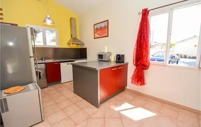 a kitchen with a refrigerator and a counter with a microwave at Cozy Home In Cabannes With Wifi in Cabannes