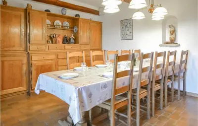 a dining room with a table and wooden cabinets at Cozy Home In Aubignan in Aubignan