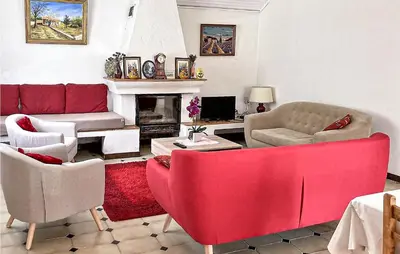a living room with red furniture and a fireplace at 2 Bedroom Cozy Home In Saint Trinit in Sault-de-Vaucluse