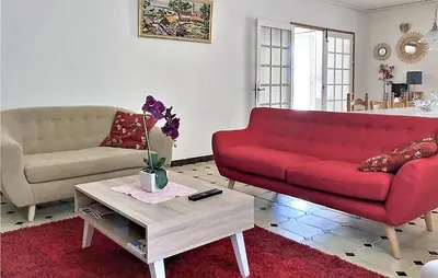 a living room with a red couch and a coffee table at 2 Bedroom Cozy Home In Saint Trinit in Sault-de-Vaucluse