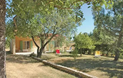a yard with two chairs and trees and a house at 2 Bedroom Cozy Home In Saint Trinit in Sault-de-Vaucluse