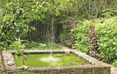 a fountain in the middle of a pond in a garden at Nice Home In St Didier With Kitchen in Saint-Didier