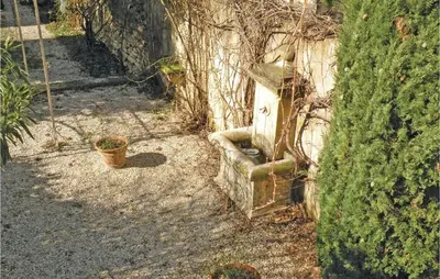 an old ivy covered wall with a bench next to a house at Nice Home In St Didier With Kitchen in Saint-Didier