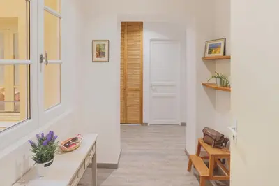 a hallway with white walls and a table and a door at nid2nuit Nuance d'Ocres in Apt