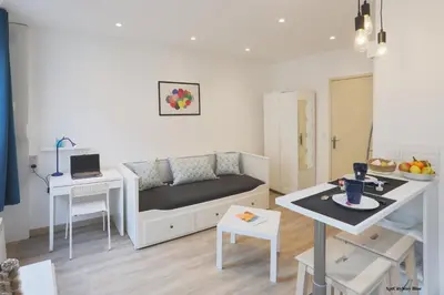 a small living room with a bed and a table at AptCityStay in Apt