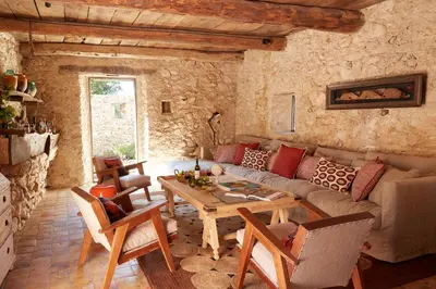 a living room with a couch and a table at Le Mas Vermentino, La Bastide de Marie, Villa avec services in Ménerbes