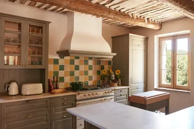 a kitchen with a stove and a counter top at Le Mas Vermentino, La Bastide de Marie, Villa avec services in Ménerbes