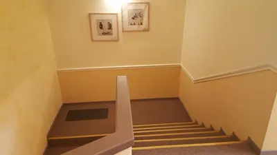 a hallway with stairs and paintings on the wall at Le Mas Du Colombier in Cadenet