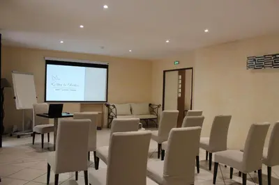 a room with chairs and a screen with a presentation at Le Mas Du Colombier in Cadenet